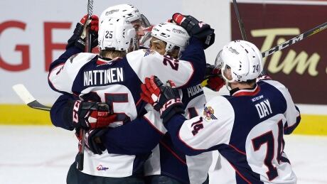 Windsor Spitfires left wing Jeremiah Addison (10) is surrounded by teammates centre Julius Nattinen (25) and defenceman Sean Day (74) after scoring against the Erie Otters during the first period. spitfires-otters