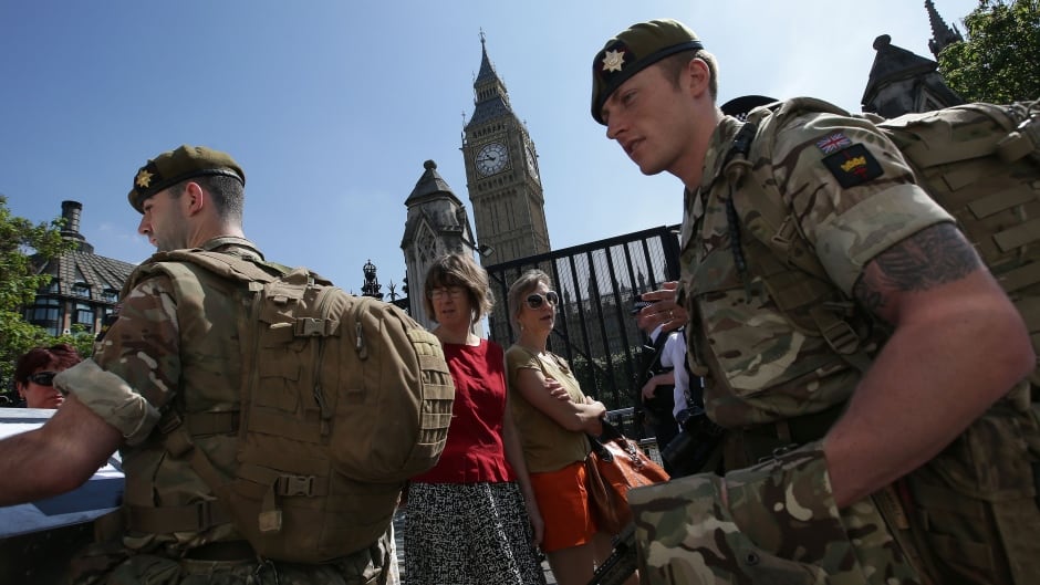 British Army soldiers patrol with police officers outside the Palace of Westminster, comprising the Houses of Parliament and the House of Lords, in central London, on May 25, 2017, following the May 22 terror attack at the Manchester Arena.