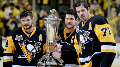 Sidney Crosby, centre, Evgeni Malkin, right and Chris Kunitz pose with the Prince of Wales Trophy after their Game 7 win Thursday over the Ottawa Senators. Senators Penguins Hockey