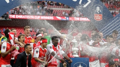Arsenal's players celebrate with the trophy after winning the English FA Cup final match between Arsenal and Chelsea. fa-cup