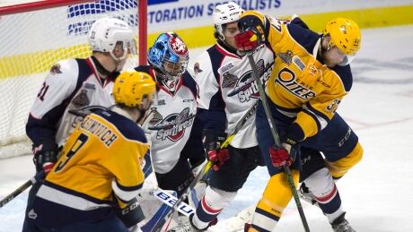 Windsor Spitfires goalie Michael DiPietro (64) keeps his eye on the puck as Erie Otters centre Warren Foegele (37) tries to deflect a shot between his legs past Spitfires defenceman Jalen Chatfield (51) during second period Memorial Cup round robin hockey action on Wednesday. memorial-cup