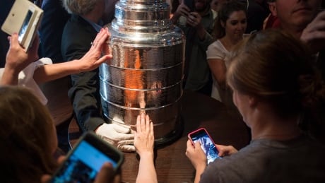 Chicago Blackhawks fans gather around the Stanley Cup trophy to take photographs as it made a stop at Phil Stefani's 427 restaurant in June 2015 in downtown Chicago. The Stanley Cup has a tradition extending a back to 1893. stanley-cup-trophy-051615-620