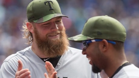 Texas Rangers starting pitcher Andrew Cashner (left) and Rangers shortstop Elvis Andrus react as they close out the fifth inning against the Toronto Blue Jays along the way to a 3-1 win in Toronto on Sunday. BBA Rangers Blue Jays 20170528