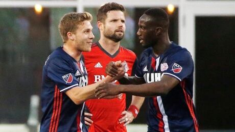 New England Revolution's Benjamin Angoua, right, celebrates his goal with teammate Scott Caldwell, left, in front of Toronto FC's Drew Moor during the first half of Saturday's game. new-england-revolution