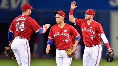 Toronto Blue Jays players (left to right) Justin Smoak, Ryan Goins and Josh Donaldson celebrate after beating the New York Yankees 3-2 in Toronto on Sunday. blue-jays-060417-620