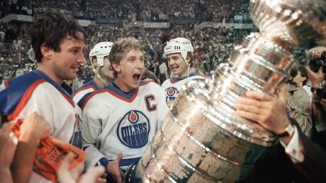 Wayne Gretzky and Paul Coffey await the presentation of the Stanley Cup after defeating the Philadelphia Flyers in the 1985 final. That team has been named by the NHL as the greatest in history. HKY-OILERS-ANNIVERSARY