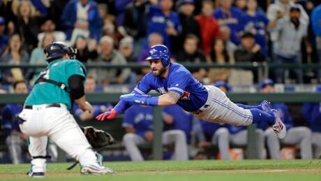Toronto Blue Jays outfielder Kevin Pillar dives for the plate but is tagged out by Seattle Mariners catcher Mike Zunino during the seventh inning on Friday in Seattle. blue-jays-mariners-060917-620