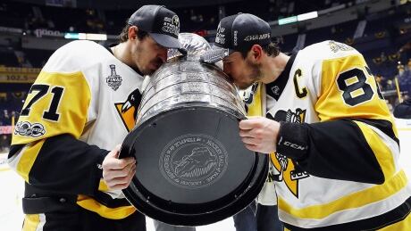 NASHVILLE, TN - JUNE 11: Evgeni Malkin #71 and Sidney Crosby #87 of the Pittsburgh Penguins kiss the Stanley Cup Trophy after defeating the Nashville Predators 2-0 in Game Six to win the 2017 NHL Stanley Cup Final at the Bridgestone Arena on June 11, 2017 in Nashville, Tennessee. (Photo by Bruce Bennett/Getty Images) crosby-malkin-cup-170611-1180