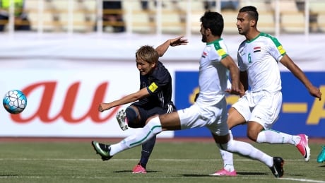 Japan's Genki Haraguchi of Japan, left, shoots past Iraqi defenders during their World Cup qualifying game Tuesday Tehran. 96249006