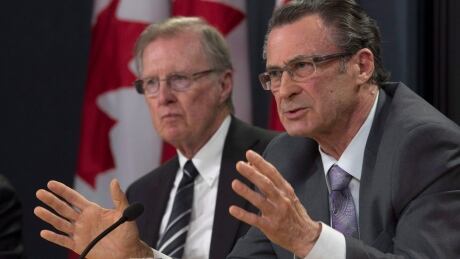 Senate committee on legal and constitutional affairs Chair Senator Bob Runciman listens as Senator George Baker responds to a question after releasing the committee's final report on court delays in Canada during a news conference in Ottawa today. Senate committee on court delays