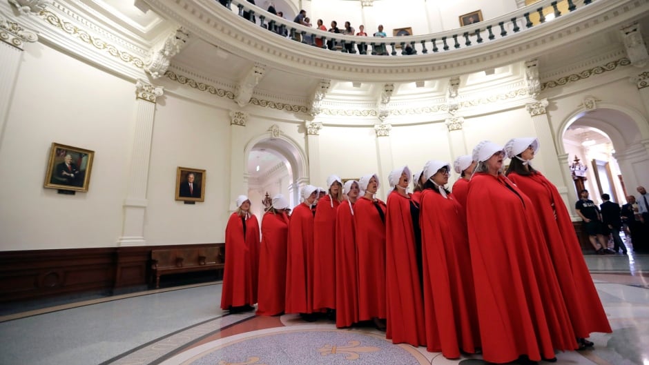 Activists dressed as characters from The Handmaid's Tale chant in the Texas Capitol Rotunda as they protest SB8.