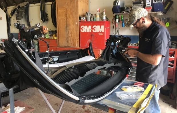 Dalziel's Autobody employee works on a convertible BMW roof