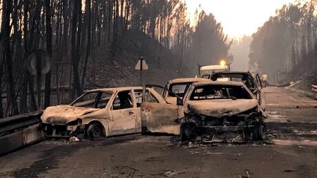 Burned cars are seen on a local road during a forest fire near Pedrogao Grande, Portugal June 18, 2017. PORTUGAL-FIRE/