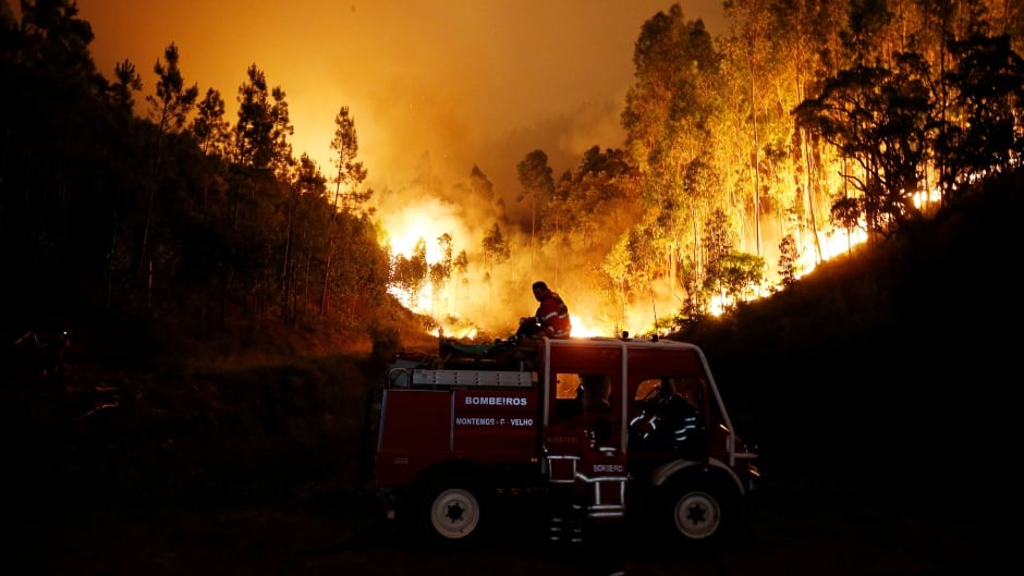 Firefighters work to put out a forest fire near Bouca, in central Portugal. The country is observing three days of national mourning for the dozens killed in the wildfires.