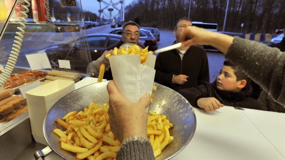 Josiane Devlaeminck serves Belgian fries to customers in Brussels. Belgium's double-fried fries are a 'culinary tradition,' says the country's tourism minister.