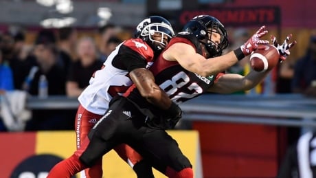 Ottawa Redblacks receiver Greg Ellingson fights to hang on to the ball in front of Calgary Stampeders' Joe Burnett. The Redblacks and Stampeders played to a 31-31 tie on Friday. Ellingson-Greg-06232017