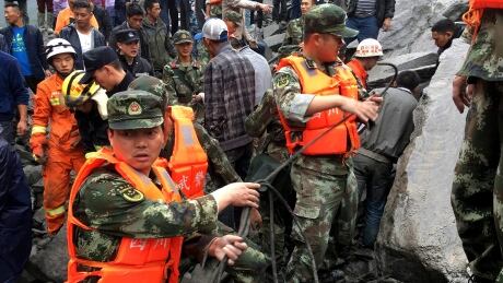 Emergency personnel work at the site of a massive landslide in Xinmo village in Maoxian County in southwestern China's Sichuan Province, Saturday, June 24, 2017. Dozens of people are feared buried by a landslide that unleashed huge rocks and a mass of earth that crashed into their homes in southwestern China early Saturday, a county government said.(Chinatopix via AP) APTOPIX China Landslide