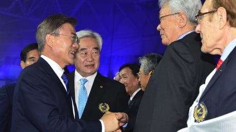 South Korea's President Moon Jae-in, left, shakes hands with a North Korean delegation led by International Olympic Committee member Chang Ung during the opening ceremony of the World Taekwondo Championships in Muju, South Korea, Saturday, June 24, 2017. South Korea Koreas Moon