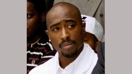 FILE - In this Aug. 15, 1996, file photo, rapper Tupac Shakur attends a voter registration event in South Central Los Angeles. A music journalist has filed an infringement lawsuit against the creators of the new Tupac Shakur biopic, claiming that portions of the film are based on his interviews with the late rapper. Plantiff Kevin Powell claims in documents filed Friday, June 23, 2017 that “All Eyez On Me” borrows from articles he wrote and interviews he had done with Shakur in the 1990s for Vibe magazine. Tupac Biggie Smalls Pilot