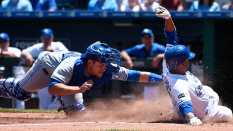 Alcides Escobar of the Kansas City Royals slides safely into home to score past the tag of Luke Maile of the Toronto Blue Jays in the third inning on Saturday in Kansas City. blue-jays-062417-620