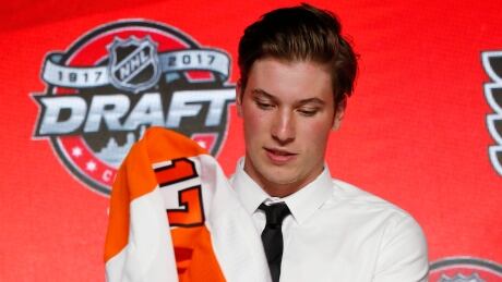 Nolan Patrick puts on a Philadelphia Flyers jersey after being selected by the team in the first round of the NHL hockey draft, Friday, June 23, 2017, in Chicago. NHL Draft Hockey
