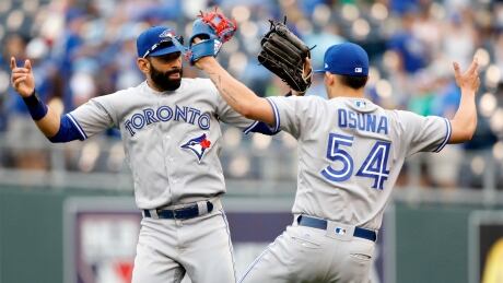 Toronto Blue Jays' Jose Bautista, left, and pitcher Roberto Osuna, right, celebrate at the end of a game against the Kansas City Royals on Sunday. osuna-bautista