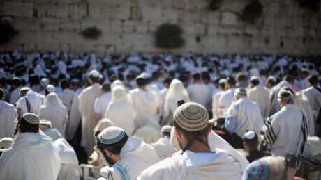 FILE -- In this May 24, 2017 file photo, Jewish men pray at the Western Wall, the holiest place where Jews can pray, in Jerusalem's Old City, during Jerusalem Day celebrations. An Israeli official said Sunday, June 25, 2017 that the government has frozen a long-overdue plan to open a mixed-gender prayer area at Jerusalem's Western Wall. Israel Western Wall
