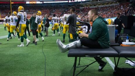 Edmonton Eskimos' linebacker J.C. Sherritt, right, sits on the sideline with a boot on his leg after rupturing his Achilles tendon during Saturday's game against the B.C. Lions. FBO CFL Eskimos Lions 20170624