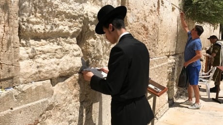 A man recites prayers at the Western Wall, the holiest site for Jews to pray. man-prays