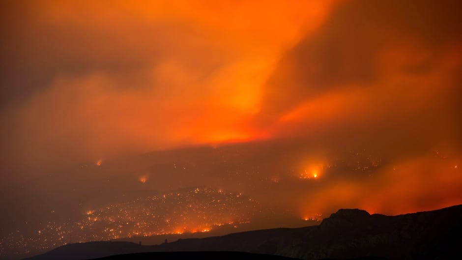 A wildfire burns on a mountain in the distance east of Cache Creek, B.C., in the early-morning hours of July 10, 2017.