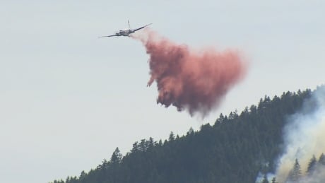 A fixed wing air tanker drops fire retardant over a fire near Fort Little B.C. B.C. Fires 2017