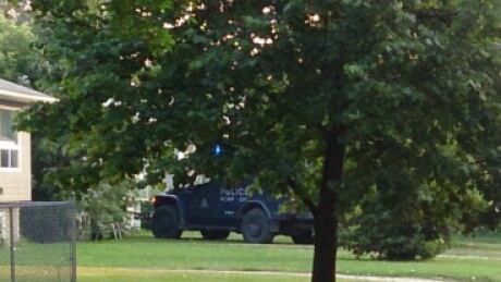 A vehicle from the RCMP emergency response team sits on the lawn of a home on Oak Bay in Portage la Prairie. RCMP surround home
