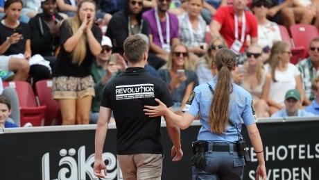 A man wearing a black t-shirt with neo-nazi slogans is walked off the court at the Swedish Open after raising his arm in a Nazi-like salute on Saturday, in Bastard Sweden.
Swedish-Open-22072017