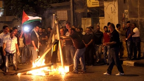 Palestinians burn mock metal detectors during a demonstration in Bethlehem, Sunday, July 23, 2017. Israel's minister of public security said Sunday that metal detectors set at the entrance to a major Jerusalem shrine that angered Palestinians could be removed if police have another way of ensuring security there. Israel Palestinians