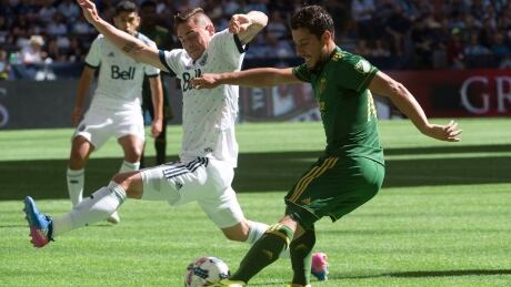 Vancouver Whitecaps defender Jake Nerwinski (28) fights for control of the ball with Portland Timbers midfielder Sebastian Blanco (10). timbers-whitecaps