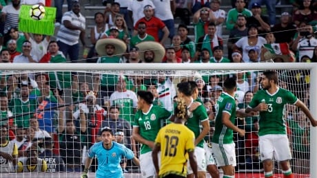Mexico goalkeeper Jesus Corona, left, watches a goal scored by Jamaica's Kemar Lawrence during the second half. mexico-jamaica