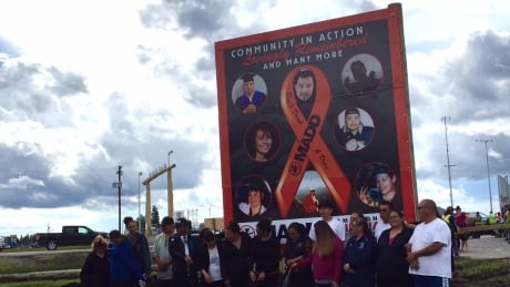 The families of drunk driving victims in Norway House stand beside a new billboard awareness campaign. Norway House Billboard