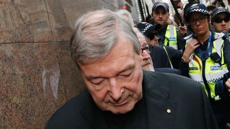 MELBOURNE, AUSTRALIA - JULY 26: Cardinal George Pell walks with a heavy Police guard from the Melbourne Magistrates' Court on July 26, 2017 in Melbourne, Australia. Cardinal Pell was charged on summons by Victoria Police at Melbourne Magistrates' Court on July 26, 2017 in Melbourne, Australia. Cardinal George Pell was charged on summons by Victoria Police on 29 June over multiple allegations of sexual assault. Cardinal George Pell is Australia's highest ranking Catholic and the third most senior Catholic at the Vatican, where he was responsible for the church's finances. Cardinal George Pell has leave from his Vatican position while he defends the charges. 96816691