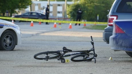 An evidence marker sits beneath a bike on the pavement in the area where someone was stabbed in Gimli, Man. Stabbing in Gimli