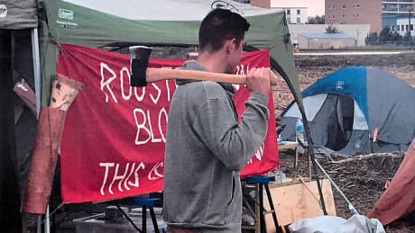 Gem Equities claims this Parker protester followed one of its employees around the site with an axe. Protesters say it was used to chop wood for a fire and insist there are no weapons at their encampment. Parker protestor