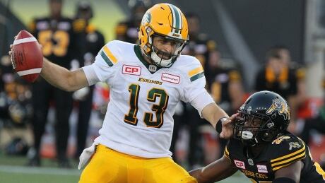 Edmonton Eskimos quarterback Mike Reilly (13) fends off Hamilton Tiger-Cats defensive back Terrence Frederick (25) during first half CFL football action in Hamilton, Ont. on Thursday, July 20, 2017. THE CANADIAN PRESS/Dave Chidley reilly-mike-170720-1180