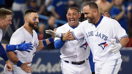 Kendrys Morales is greeted at home plate after his solo shot in the bottom of the ninth inning completed the Jays' 3-2 comeback win against the Oakland A's Wednesday. BBA Athletics Blue Jays 20170726