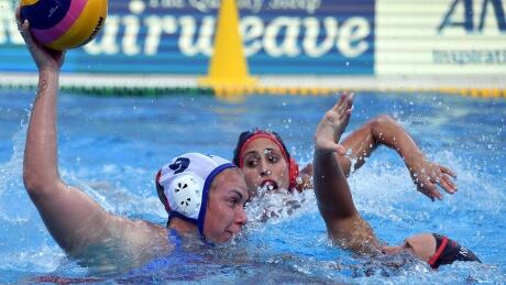 Anna Timofeeva, left, beats Canada's Elyse Lemay-Lavoie, right, with a shot to score for Russia in Friday's bronze-medal game in women's water polo at the world aquatics championships in Budapest on Friday. The Russians won 11-9 for their fifth world bronze all-time. timofeeva-anna-170728-1180