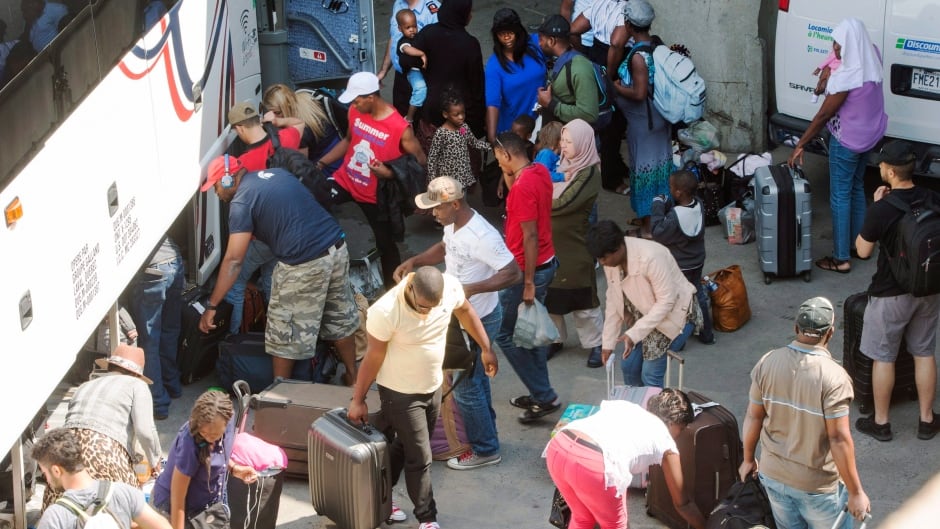 Asylum seekers arrive at Montreal's Olympic Stadium, on Wednesday, August 2, 2017.