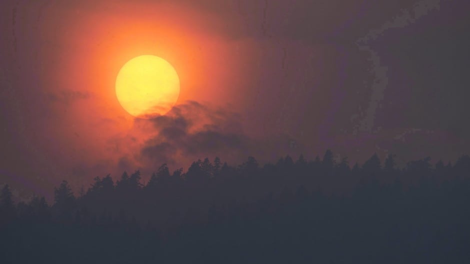 Smoke is seen rising in front of the sun as a wildfire burns near Little Fort, B.C.