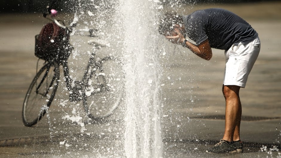 A man refreshes himself with the waters of a fountain at Turin's Piazza Castello, Aug. 2, 2017, seeking relief from a heat wave that continues to grip southern Europe.