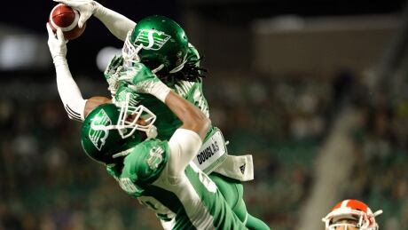 Saskatchewan Roughriders defensive back Ed Gainey outleaps teammate Duron Carter to record his fourth interception during the second half. gainey-ed