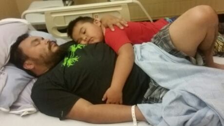 Bryce Gray, 5 years old, lays beside his dad, Chuck Gray, 37 years old, at Mills Memorial Hospital in Terrace, B.C. Chuck Gray and son Bryce