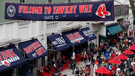 In this April 4, 2014 file photo, fans enjoy pre-game festivities along Yawkey Way outside Fenway Park in Boston. Boston Red Sox principal owner John Henry says he wants to take steps to rename all of Yawkey Way, a street that has been an enduring reminder of the franchise's complicated racial past. yawkey-way
