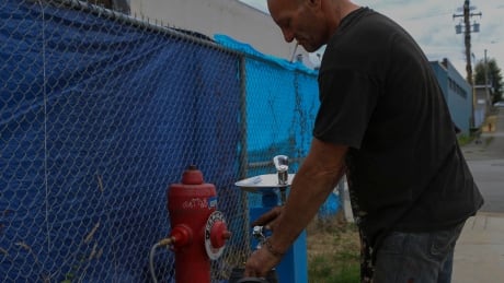 Sugar Mountain tent city resident Ward Ferguson says the newly installed water station is a huge improvement over hauling salvaged water from nearby businesses. sugar mountain tent city